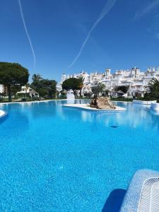 a large blue swimming pool with buildings in the background at ATLANTERRA PUEBLO in Zahara de los Atunes