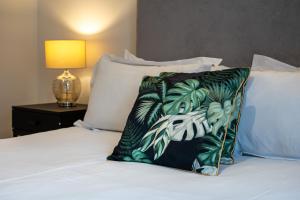 a pillow sitting on top of a bed next to a lamp at Stylish LUXE 4Beds Abbey Rd St Johns Wood in London