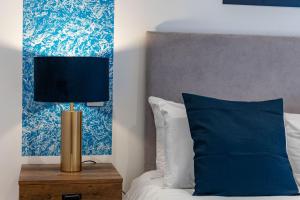 a bed with a lamp on a night stand next to a bed at Stylish LUXE 4Beds Abbey Rd St Johns Wood in London
