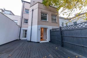 a house with a fence on a wooden deck at 4 Bedrooms Peaceful Home Abbey Rd - St Johns Wood in London