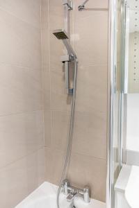 a shower with a shower head in a bathroom at 4 Bedrooms Peaceful Home Abbey Rd - St Johns Wood in London +135 photos