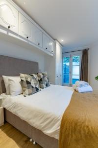 a bedroom with a large white bed with pillows at 4 Bedrooms Peaceful Home Abbey Rd - St Johns Wood in London