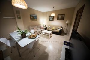 ein Wohnzimmer mit Tisch und Couch in der Unterkunft Ático Barrio de los Pescadores in Costa Ballena