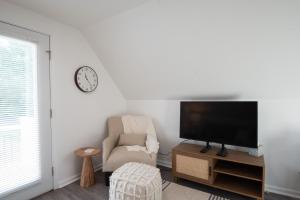 ein Wohnzimmer mit einem TV und einem Stuhl in der Unterkunft The Wren's Nest in Birdsboro
