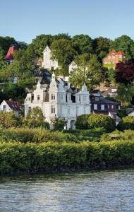 a large white house on a hill next to the water at stilwerk Strandhotel Blankenese in Hamburg