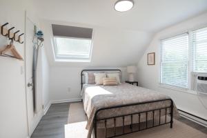a bedroom with a bed and two windows at The Wren's Nest in Birdsboro