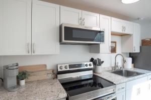 a kitchen with white cabinets and a stainless steel stove at The Wren's Nest in Birdsboro