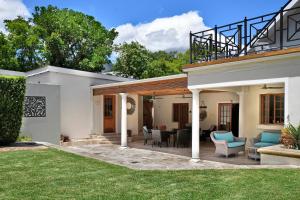 a house with a patio with chairs and tables at The Coach House in Franschhoek +42 photos