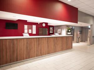 um hall de entrada de um hospital com uma parede vermelha em Campanile Swindon em Swindon