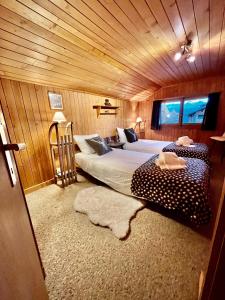 Chalet atypique Colorado Crans-Montana في كرانس مونتانا: غرفة نوم بسريرين في غرفة خشبية