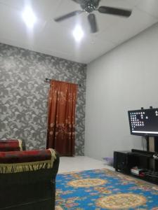 sala de estar con ventilador de techo y sofá en Nur Aisyah homestay, en Kampong Kemaman
