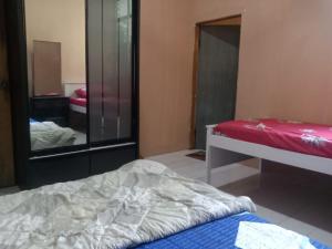 Schlafzimmer mit einem Bett und einem Spiegel in der Unterkunft Nur Aisyah homestay in Kampong Kemaman