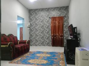 ein Wohnzimmer mit einem Sofa und einem Teppich in der Unterkunft Nur Aisyah homestay in Kampong Kemaman