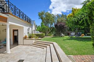a house with a patio and a yard at The Coach House in Franschhoek