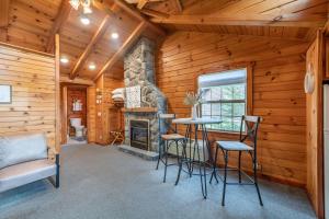 a living room with a fireplace and a table and chairs at Olive Leaf Cabin in Millersburg
