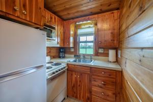 a kitchen with wooden cabinets and a refrigerator at Arrowhead Cabin/Fields of Home in Millersburg
