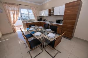 uma cozinha e sala de jantar com mesa e cadeiras em Francis Flats Modern Penthouse em Mellieħa
