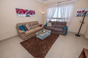 - un salon avec un canapé et une table dans l'établissement Francis Flats Modern Penthouse, à Mellieħa