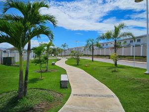 a walking path in a park with palm trees at Vista al mar 303 in ArraijÃ¡n