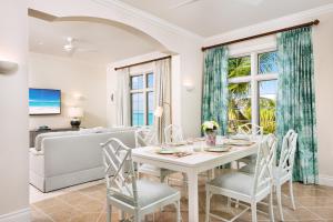 uma sala de jantar com uma mesa e cadeiras e um sofá em Point Grace em Grace Bay