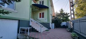 een huis met een trap, een raam en een hek bij Diva Apartments in Satu Mare