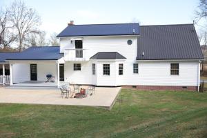 una casa bianca con tetto nero e patio di The Kennedy House a Grayson