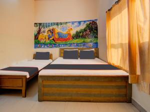 two beds in a room with a painting on the wall at Collection O Hotel Mansagar in Jaipur