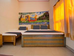 a room with two beds and a painting on the wall at Collection O Hotel Mansagar in Jaipur