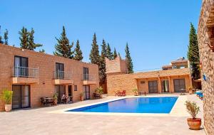 una piscina frente a un edificio de ladrillo en bungalows vert 2 en Essaouira