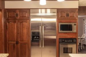 a kitchen with a stainless steel refrigerator and wooden cabinets at Dogwood Retreat with pool in Warsaw