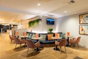a lobby with a couch and tables and chairs at Holiday Inn - Glasgow Airport by IHG in Paisley