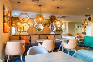 a restaurant with tables and chairs and lights at Holiday Inn - Glasgow Airport by IHG in Paisley