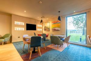a meeting room with tables and chairs and a tv at Holiday Inn - Glasgow Airport by IHG in Paisley