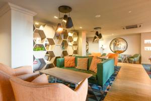a lobby with couches and a table and chairs at Holiday Inn - Glasgow Airport by IHG in Paisley