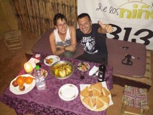 un hombre y una mujer sentados en una mesa con comida en Obira Oasis Merzouga Camp, en Merzouga