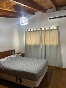a bedroom with a bed and a chandelier at Depto céntrico General Alvear in General Alvear