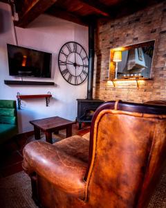 a leather chair in a living room with a clock on the wall at Vespa House in Igrejinha