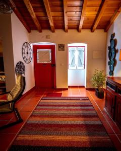 a living room with a red door and a chair at Vespa House in Igrejinha