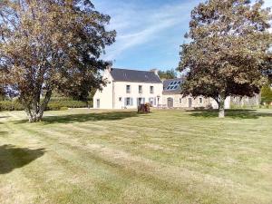 a large white house with two trees in the yard at Gite de Kerantum in Mahalon