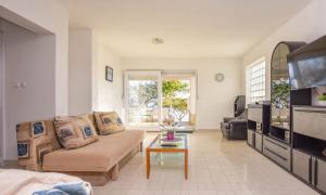 a living room with a couch and a tv at House Marrie Lou in Banj