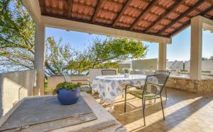 a patio with a table and chairs under a roof at House Marrie Lou in Banj