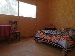 曼科拉的住宿－Maison Nim，一间卧室设有一张床和一个大窗户