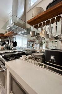 a kitchen with a stove and some pots and pans at Avalon Beach Cottage- The Islander in Avalon