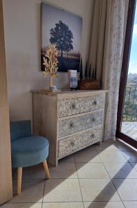 een dressoir en een stoel in een kamer met een raam bij GLI ALBERI apartment with view in Montepulciano