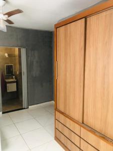Habitación con una gran puerta de madera y TV. en Kitnet dos Alves en Maricá