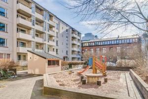 un parque infantil frente a un edificio de apartamentos en Modern One-Bedroom with glazed sun balcony, 350m metro, en Helsinki