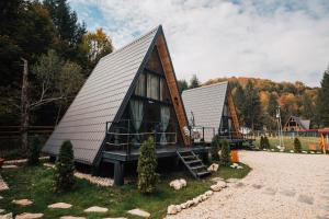 a small house with a gambrel roof at Campulung Chalets in Bughea de Sus