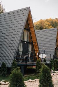 a house with a large window and a balcony at Campulung Chalets in Bughea de Sus