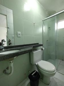 a bathroom with a toilet and a sink and a mirror at Hotel Vitoria Iracema in Juazeiro do Norte