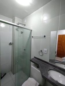 a bathroom with a glass shower and a sink at Hotel Vitoria Iracema in Juazeiro do Norte